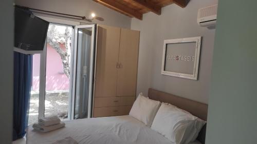 a bedroom with a bed and a tv and a window at Lea's Apartment in Kourouta