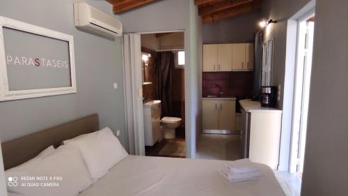 a bedroom with a white bed and a bathroom at Lea's Apartment in Kourouta