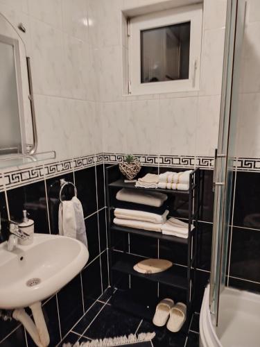 a black and white bathroom with a sink and a mirror at Roza in Ruma