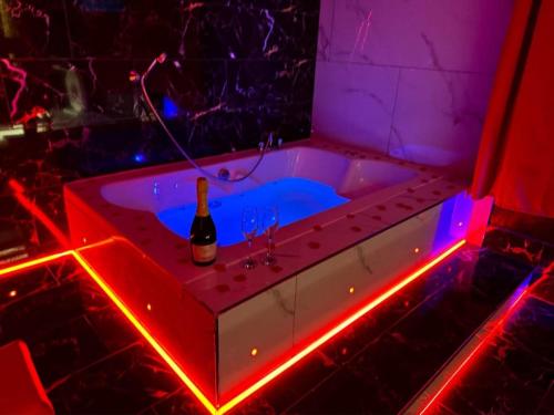 a bath tub with a bottle of wine in it at Luxury Suites in Bradford