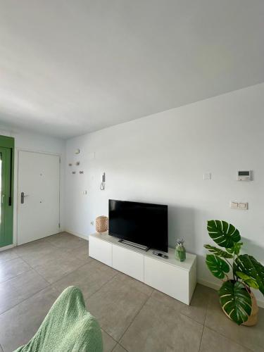 a living room with a flat screen tv on a white wall at OCEAN APARTAMENT !! 1ª Línea del Mar, piscina, parking, wifi in Mojácar