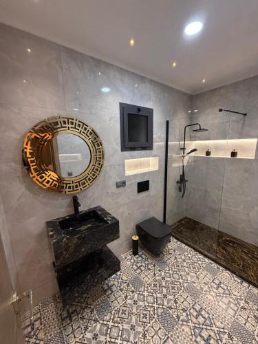 マルティルにあるAppartement haut standing 2 chambres piscine Martilの洗面台、鏡、シャワー付きのバスルーム