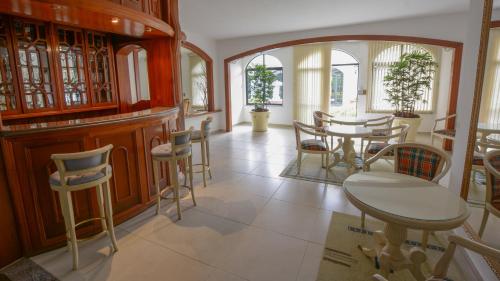 uma sala de jantar com mesas e cadeiras e um espelho em Biazi Paradise Hotel em Serra Negra