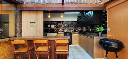 Una cocina con una gran mesa y sillas de madera. en Bamboo Búzios Hostel, en Búzios