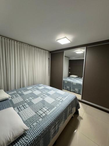a bedroom with a bed and a large mirror at Ap inteiro St Bueno 2 quartos in Goiânia