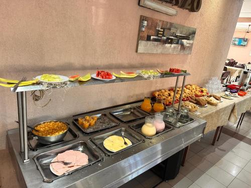een buffet met veel verschillende soorten eten bij Hotel en villa carlos paz centrico con desayuno y pileta Nuevo Enzo in Villa Carlos Paz