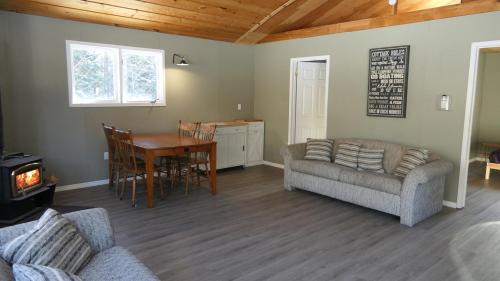 Meadowlark Cabin #5 في Maynooth: غرفة معيشة مع أريكة وطاولة طعام