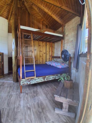 ein Schlafzimmer mit einem Etagenbett in einer Holzhütte in der Unterkunft Bangalô Pé na Areia in Imbituba