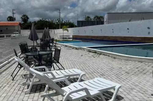 巴纳伊巴Casa em Parnaíba的一组椅子和桌子,位于游泳池旁