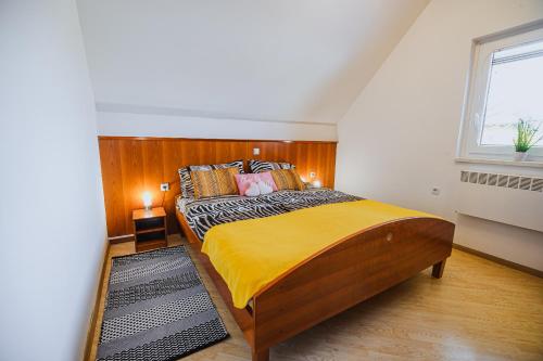 une chambre avec un grand lit avec une tête de lit en bois dans l'établissement Casa Termalis in Terme Čatež, à Brežice
