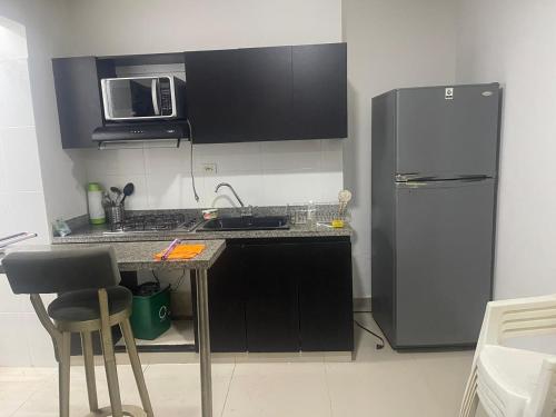 a kitchen with a stainless steel refrigerator and a counter at Apartaestudio La Castellana in Montería