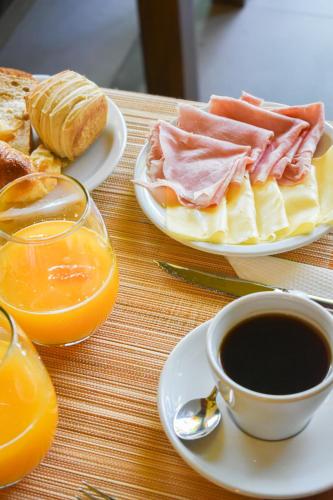 a table with two plates of food and a cup of coffee at Hotel San Germán de Muñiz in Muñiz