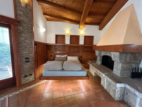 Un dormitorio con una cama y una chimenea de piedra. en Resort Ninfea San Pellegrino Terme, en San Pellegrino Terme