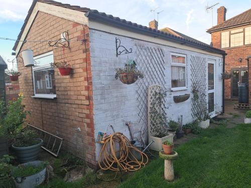 ein Backsteinhaus mit Pflanzen nebeneinander in der Unterkunft Charming Garden Guest House in Hayes & Harlington in Hayes