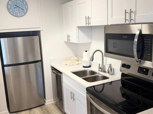 a kitchen with a stainless steel refrigerator and a sink at Tropical Isle 209 w Convenient Beach Access in Fort Walton Beach