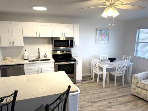 a kitchen and living room with a table and a dining room at Tropical Isle 209 w Convenient Beach Access in Fort Walton Beach
