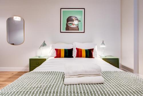 ein Schlafzimmer mit einem großen weißen Bett mit zwei Lampen in der Unterkunft Amity Moonbirds by Artsy in Raynes Park