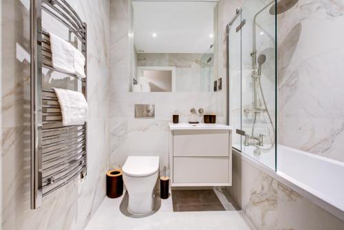 ein weißes Badezimmer mit Toilette und Dusche in der Unterkunft Amity Moonbirds by Artsy in Raynes Park