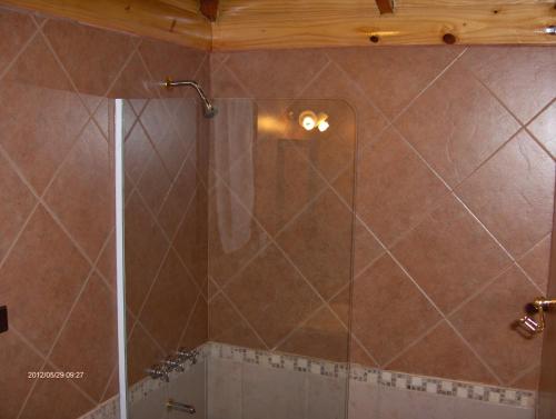 eine Dusche mit Glastür im Badezimmer in der Unterkunft Cabañas Kalfulafquen in Villa La Angostura