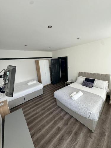 ein Schlafzimmer mit zwei Betten und einem Fernseher in der Unterkunft The residency appartment's in Litherland
