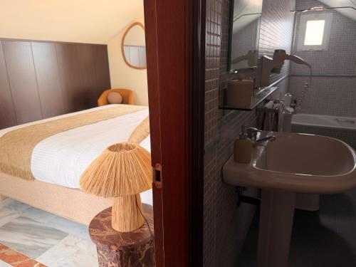 een badkamer met een bed, een wastafel en een wastafel bij CASABA - Boutique - Torre del Mar in Torre del Mar