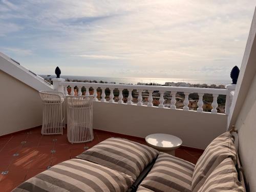 een balkon met een bank en uitzicht op de oceaan bij CASABA - Boutique - Torre del Mar in Torre del Mar
