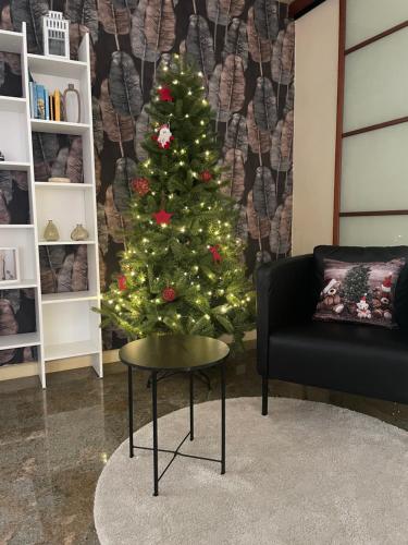 a christmas tree in a living room with a table at La casa di Erika in Almè
