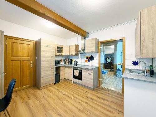 een keuken met witte muren en houten kasten bij Haupthaus in Troisdorf