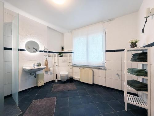 een witte badkamer met een wastafel en een toilet bij Haupthaus in Troisdorf