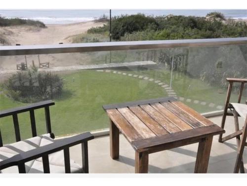 een houten bank bovenop een balkon bij Club carilo playa Edificio del bosque in Carilo