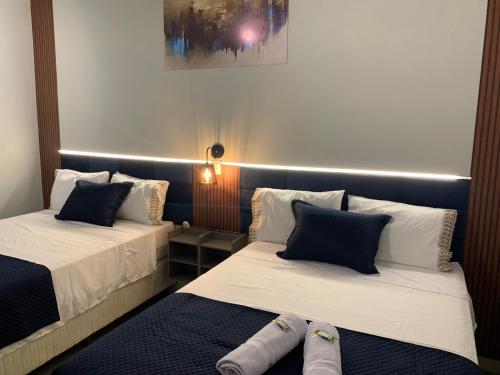 twee bedden in een kleine kamer met bij 101-Quarto Pousada Hg in Vila Nova do Sul