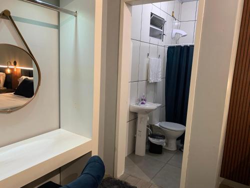 een badkamer met een wastafel, een toilet en een spiegel bij 101-Quarto Pousada Hg in Vila Nova do Sul