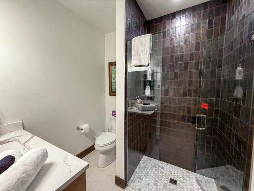 een badkamer met een douche, toilet en wastafel bij Mountain Magnificence in Outback Mobile Home Settlement