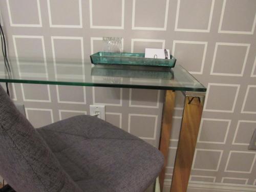 a glass table with a chair next to a wall at Washington Park Inn in Albany