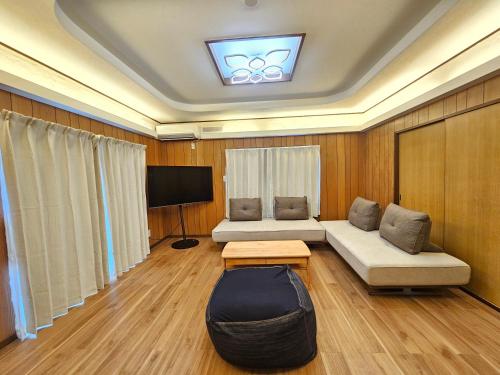 un soggiorno con due divani e una televisione di furano lavender house a Furano