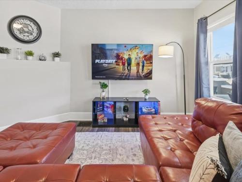a living room with a leather couch and a flat screen tv at Prime Downtown Indy House Close to DT Indy in Indianapolis