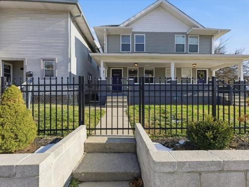 a house with a fence in front of a house at Prime Downtown Indy House Close to DT Indy in Indianapolis