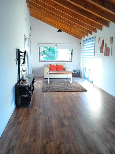 a living room with a white couch and wooden floors at Runa, Marcos de los Reyes villa serrana in Minas