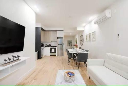 a kitchen and living room with a table and a couch at Luxury 2BR Duplex 5min to Central Park in New York