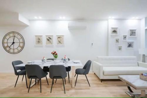 a dining room with a table and chairs and a clock at Luxury 2BR Duplex 5min to Central Park in New York