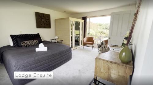 a bedroom with a bed and a living room at Vibrant Living Retreat in Hanmer Springs