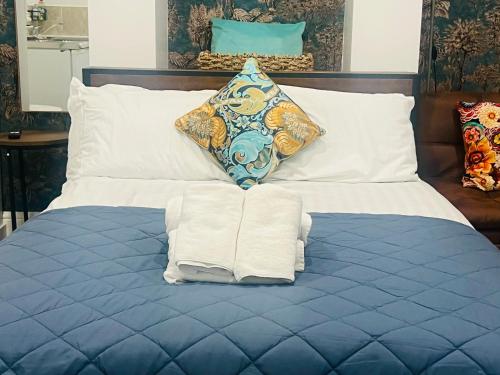 een bed met witte lakens en handdoeken erop bij Central London Boutique Apartments in Londen