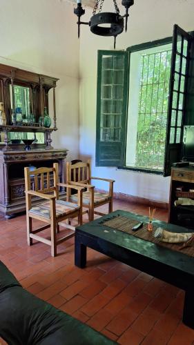 a living room with wooden chairs and a table at Chacra del Molino in Navarro