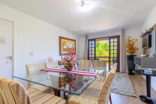 a dining room with a glass table and chairs at Suítes Jurerê Internacional in Florianópolis