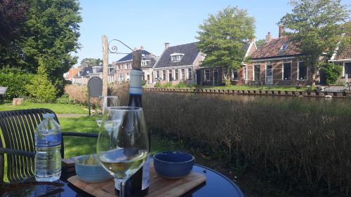 een glas witte wijn op een tafel bij Noardlik B&B in Birdaard
