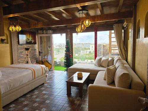 uma sala de estar com duas camas e um sofá em Rooftop studio with ocean view em Essaouira