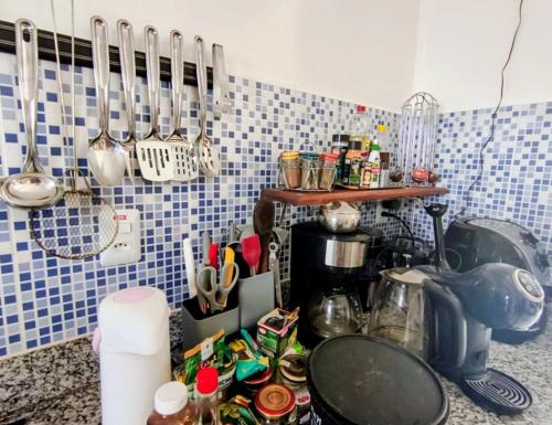 a kitchen with a counter with utensils on the wall at Casa de Adobe in Lençóis