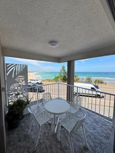 a table and chairs on a balcony with a view of the beach at Uninterrupted Ocean & Channel Views in The Entrance
