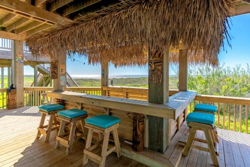 een bar op het terras van een resort met barkrukken bij Just One More Day Home in Bolivar Beach