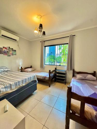 ein Schlafzimmer mit zwei Betten und einem großen Fenster in der Unterkunft Sobrado no centro da Cidade in Palmas